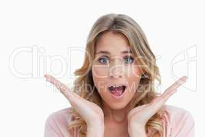 Surprised young woman raising her hands