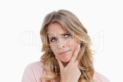 Serious young woman placing her fingers on her chin