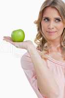 Smiling young woman holding a green apple