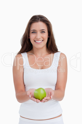 Smiling woman looking at the camera while holding an apple