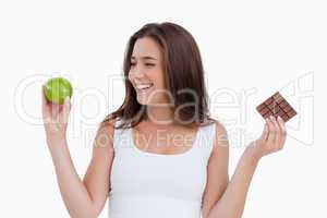Smiling young woman looking at a green apple