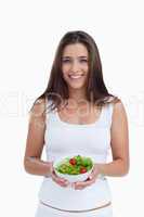 Smiling young woman holding a bowl of salad