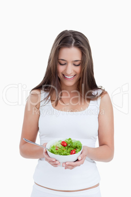 Smiling brunette woman holding a bowl of salad