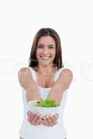 Smiling young woman holding a salad
