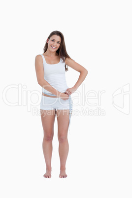 Smiling woman measuring her waist