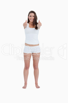 Smiling brunette woman placing her thumbs up