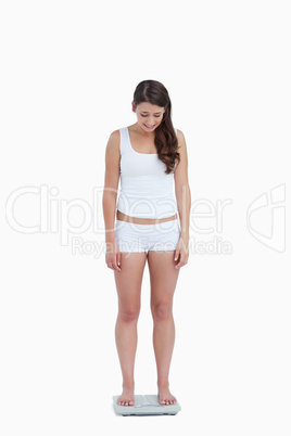 Young woman looking at her weighing scales