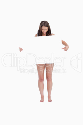 Brunette woman pointing a blank poster