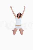 Smiling woman jumping with arms raised