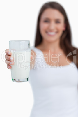 Glass of milk being held by a young brunette woman