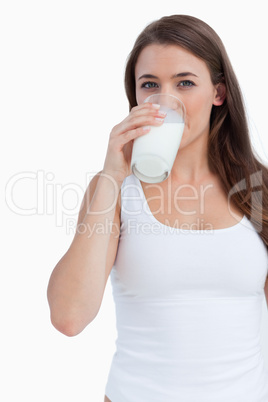 Young brunette woman drinking a glass of milk