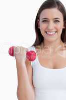 Smiling woman looking at the camera while holding a weight