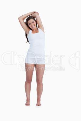 Smiling woman standing with arms crossed above her head