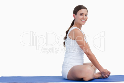 Young woman looking at the camera while sitting on a mat