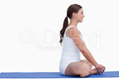 Brunette woman sitting on a yoga mat