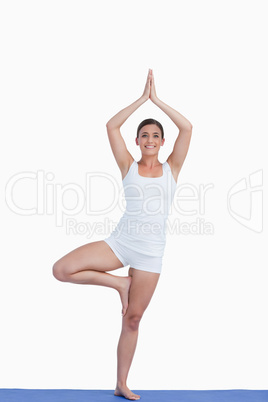 Smiling brunette woman practicing yoga