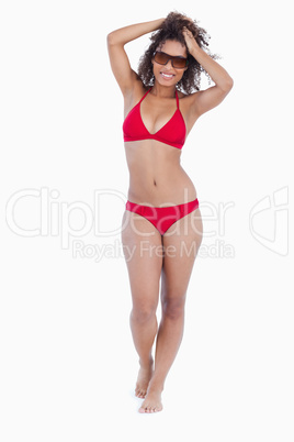 Smiling brunette woman placing her hands on her head