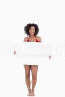 Smiling woman in bikini holding a blank poster