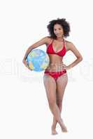 Attractive brunette woman holding a beach ball