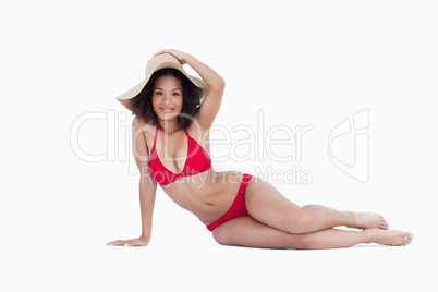 Attractive woman holding her hat while sitting down