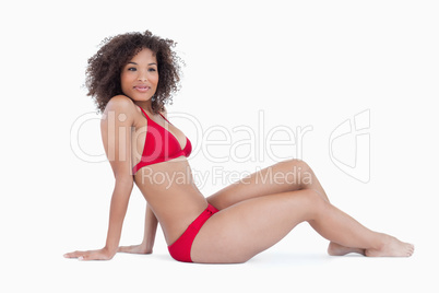 Attractive woman sitting down while placing her arms back