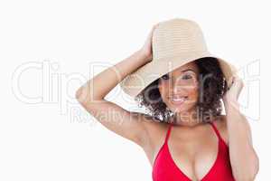 Smiling woman holding her straw hat