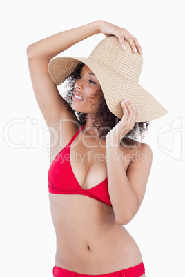 Attractive young woman looking away while holding her hat