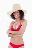 Smiling woman standing in swimsuit with arms crossed