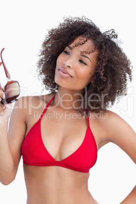 Young woman proudly holding her sunglasses