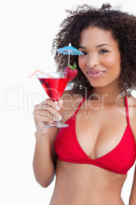 Young woman looking at the camera while holding a cocktail