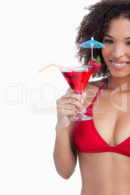 Smiling brunette looking at the camera while holding a cocktail