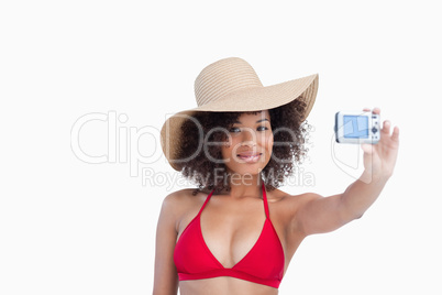 Smiling woman in beachwear photographing herself