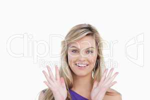 Smiling woman showing her surprise with hands raised
