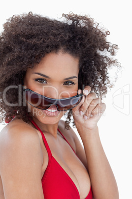 Smiling young woman looking over her sunglasses