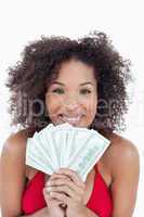 Smiling brunette holding a fan of bank notes