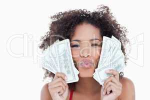 Young attractive woman puckering her lips while holding bank not