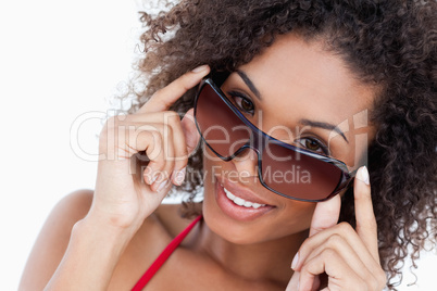 Smiling woman looking aver her sunglasses