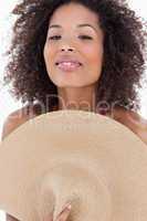 Attractive brunette woman hiding her body behind a hat