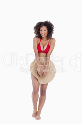 Smiling brunette woman standing upright while hiding herself