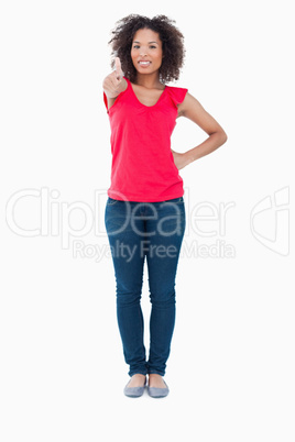 Smiling young brunette woman putting her thumbs up