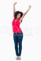 Happy young brunette raising her arms above her head