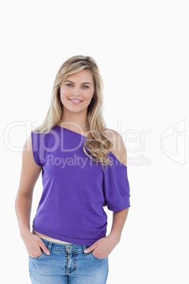 Smiling blonde woman placing her hands in her pockets