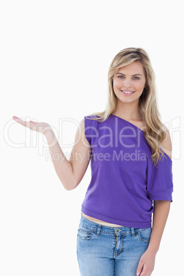 Happy blonde woman placing her palm up