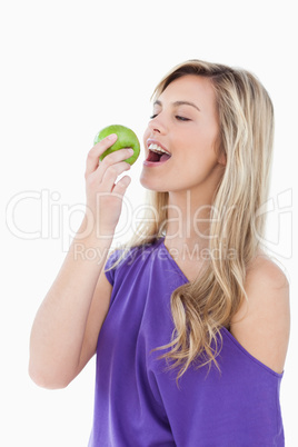 Blonde woman eating a green apple