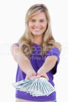Fan of bank notes being held by a blonde woman