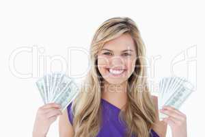 Happy blonde woman holding two fans of notes