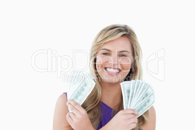 Happy blonde woman holding dollar notes