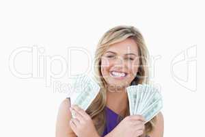 Happy blonde woman holding dollar notes