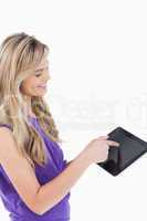 Happy blonde woman touching her tablet computer