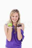 Smiling blonde holding an apple and a muffin